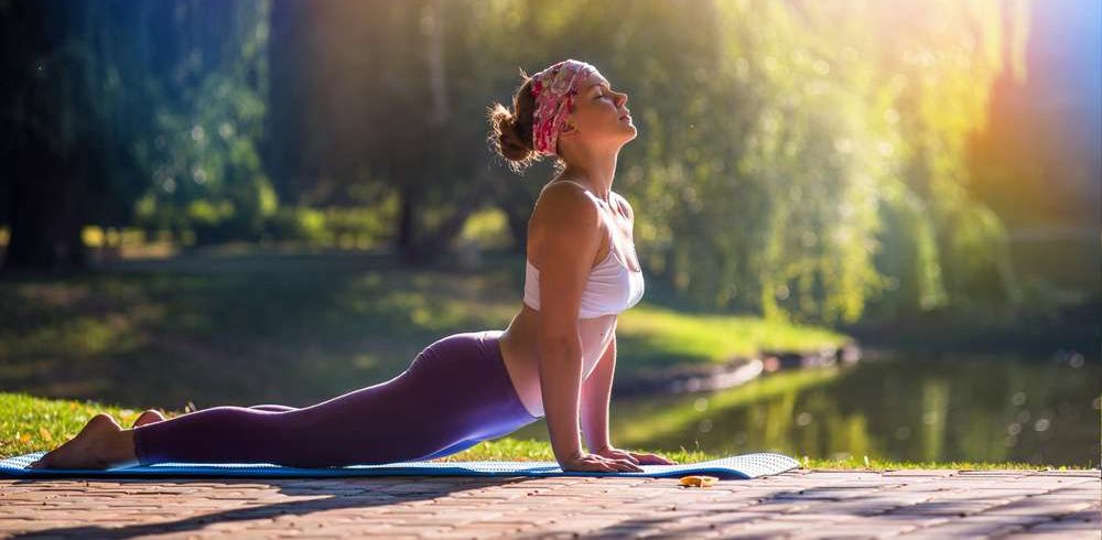 Frau macht Yoga am See