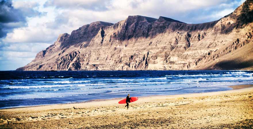 Surfer am Strand Celeta de-Famara auf Lanzarote in Spanien
