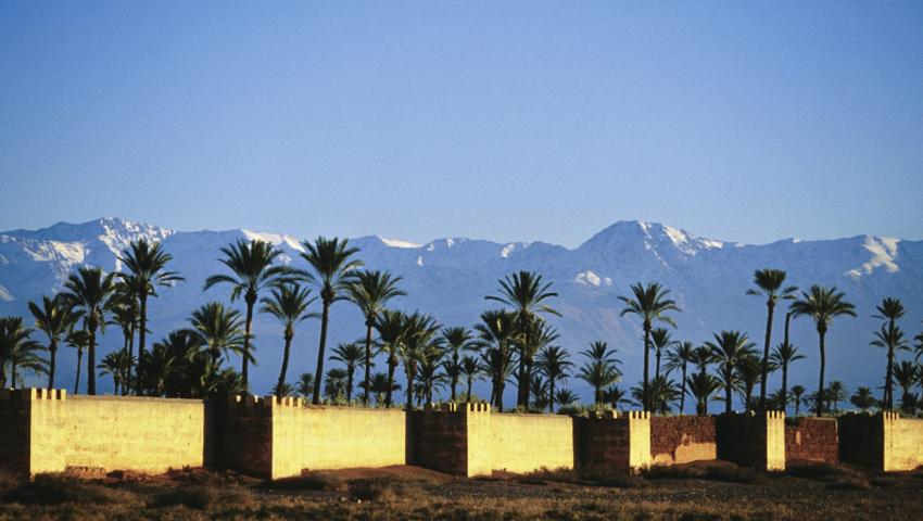 Stadtmauer in Marrakesch mit Atlas-Gebirge im Hintergrund.