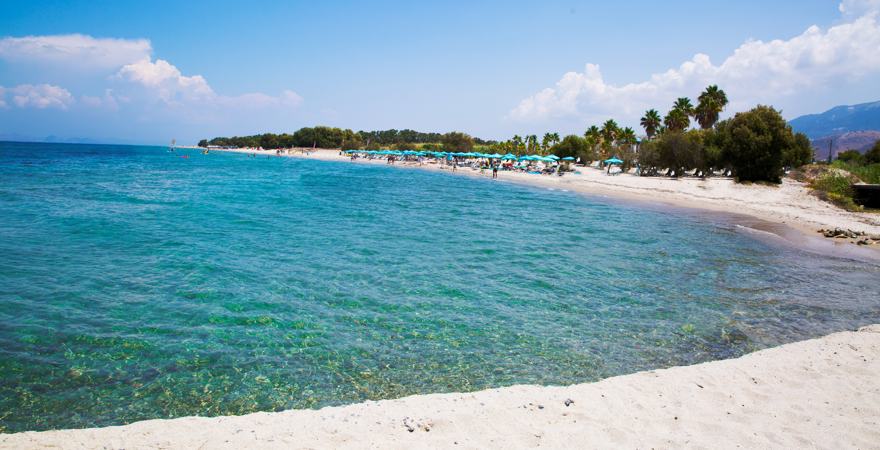 Weißer Sanstrand vor türkisblauem Wasser