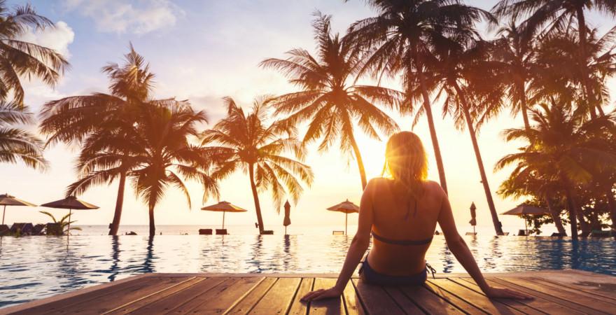 Frau an einem Pool bei Sonnenuntergang