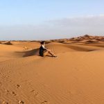 Frau auf einer Sandduene in Marokko