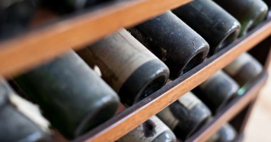 Weinregal mit verstaubten Weinflaschen