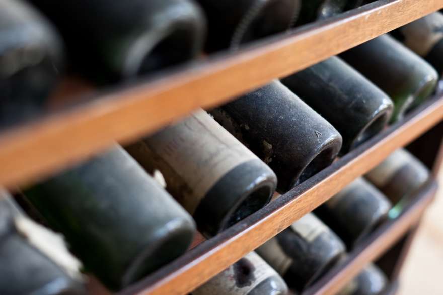 Weinregal mit verstaubten Weinflaschen