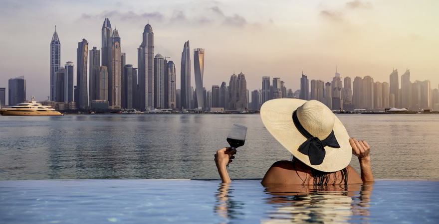 Frau in Infinitypool mit Blick auf Dubai Skyline
