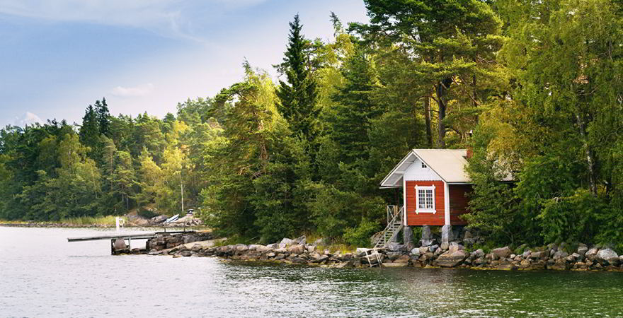 Rotes Haus mitten in der Natur am See.