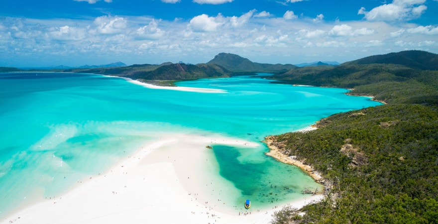 eine weiltläufige Bucht mit wieißem Strand und türkisfarbenem wasser