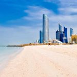 Langer Sandstrand mit Skyline im Hintergrund