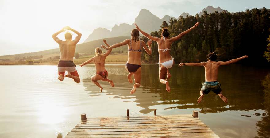 fünf Menschen springen in einen See
