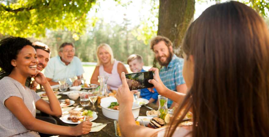 eine frau fotografieert eine gruppe beim essen