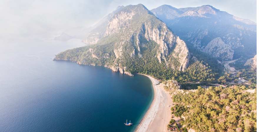 Luftaufnahme eines Strande mit Berg im hintergrund