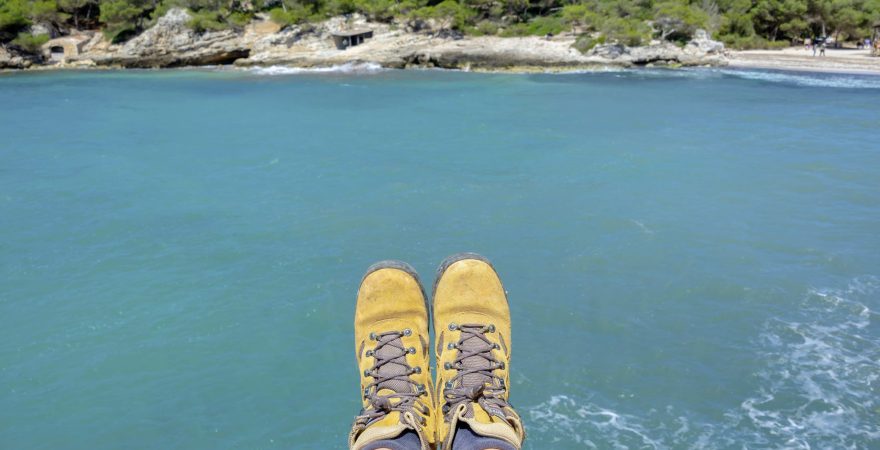 Wanderschuhe vor Bucht auf Menorca