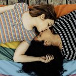 Cute lesbian couple lying together on the carpet - Image