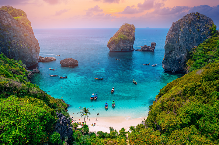 Wunderschöner Strand von Koh Phi Phi, Thailand, mit klarem Wasser und üppigen Palmen im Hintergrund.
