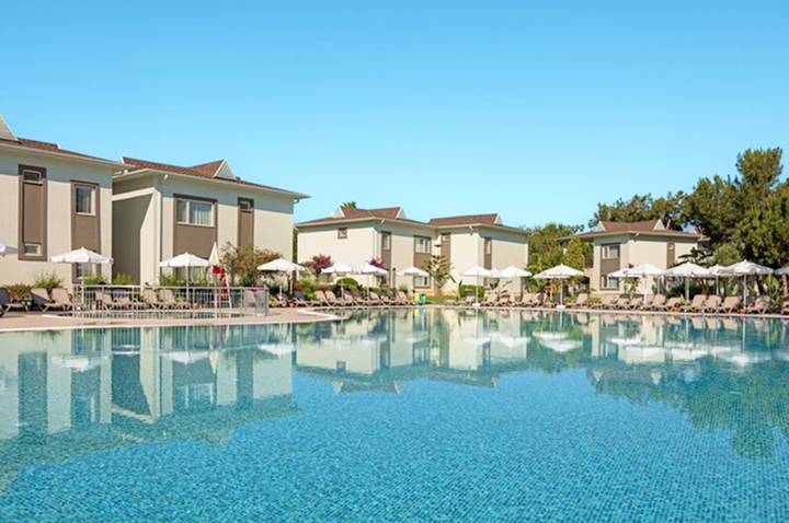 Großer Hotelpool mit Liegen und Sonnenschirmen, ideal zum Entspannen und Erfrischen an einem sonnigen Tag.