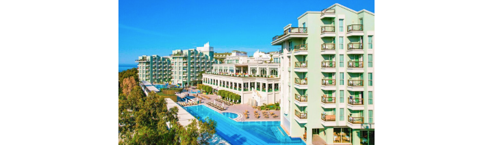 Hotelpool in der Türkei, umgeben von Liegen und Sonnenschirmen, leuchtet im sanften Licht des Sonnenuntergangs