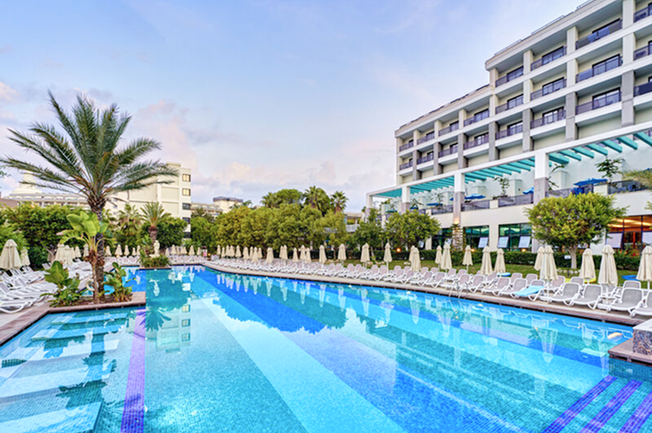 Ein Hotelpool mit Liegen und Sonnenschirmen, umgeben von einer einladenden, entspannenden Atmosphäre.