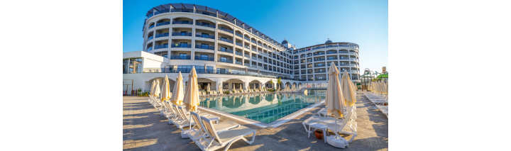 Ein modernes Hotel mit einem schönen Pool und komfortablen Liegen, ideal für Erholung und Entspannung.