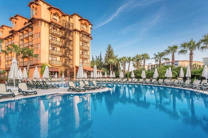 Großer Hotelpool mit Liegen und Sonnenschirmen, ideal zum Entspannen und Erfrischen an einem sonnigen Tag.