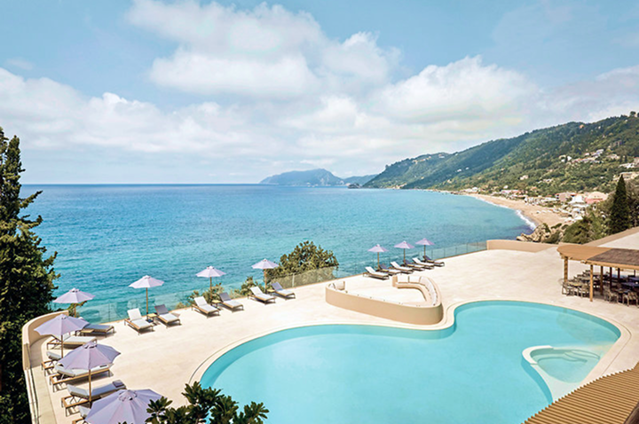 Panoramaansicht des Pools und des Strandes vom Hoteldach, mit glitzerndem Wasser und entspannenden Liegen.