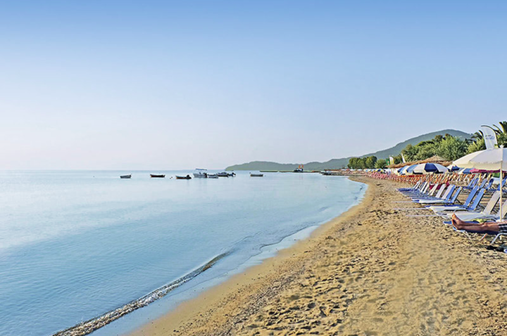 Strandansicht mit bunten Liegen und Sonnenschirmen, perfekt für Hotelbesucher, die einen entspannten Tag am Meer suchen.