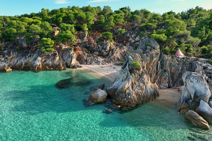 Strand mit felsigen Klippen, umgeben von klarem Wasser im Ozean, vermittelt ein Gefühl von Ruhe und Natur.