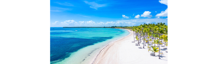 Tropischer Strand in der Dominikanischen Republik, umgeben von Palmen und klarem, blauem Wasser
