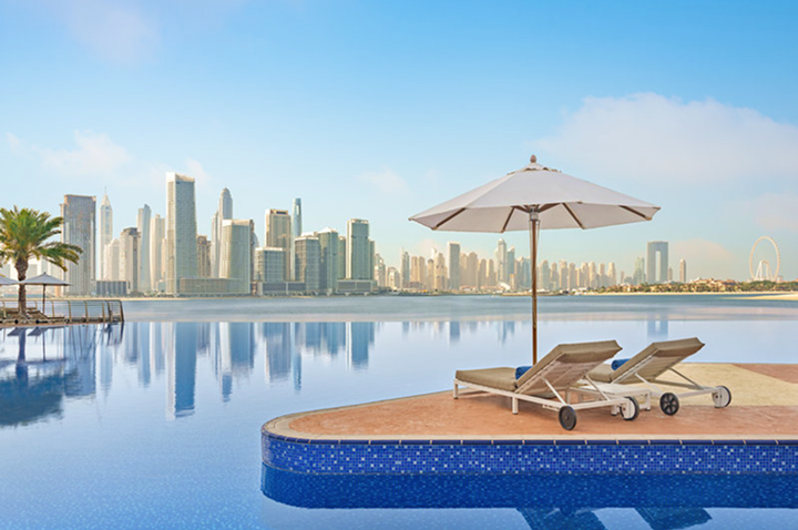 Ein Pool mit zwei Liegestühlen und einem Sonnenschirm, ideal zum Entspannen an einem sonnigen Tag.