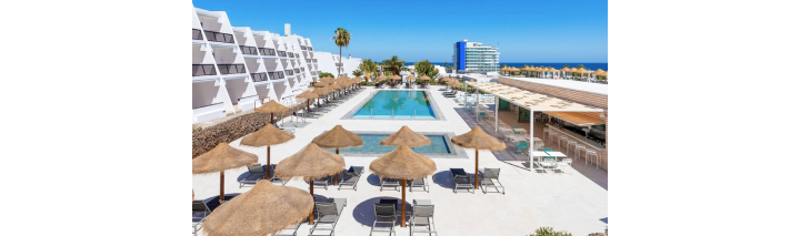Blick auf den Pool und den Strandbereich des Hotels auf Fuerteventura, umgeben von Palmen und Sonnenliegen
