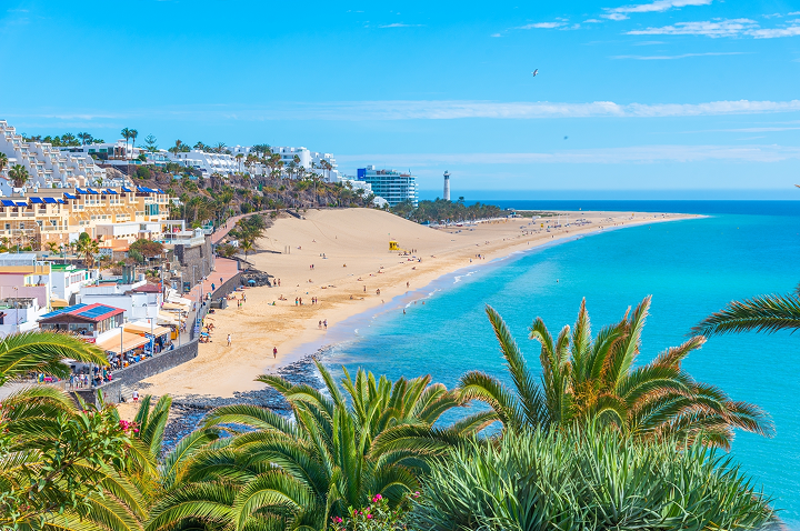 Malerischer Strand auf Fuerteventura Spanien, mit goldenem Sand und sanften Wellen unter strahlend blauem Himmel