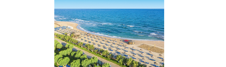 Einladender Hotelstrand mit Liegen und bunten Schirmen, ideal zum Entspannen.