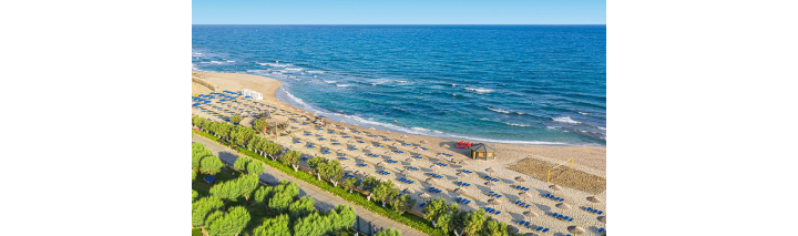 Einladender Hotelstrand mit Liegen und bunten Schirmen, ideal zum Entspannen.