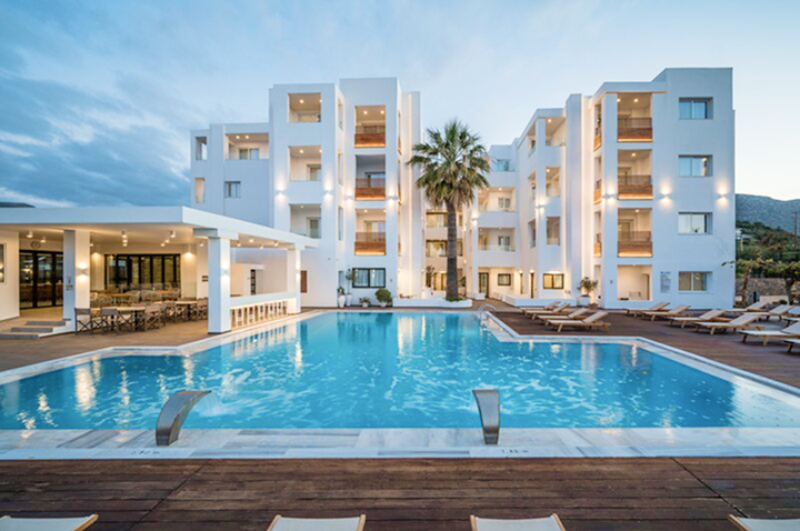 Der Pool des Hotels wird von strahlend weißen Gebäuden umrahmt, die eine einladende Urlaubsstimmung erzeugen