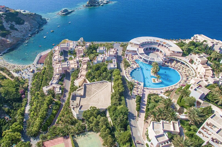 Luftaufnahme einer weitläufigen Hotelanlage mit mehreren Gebäuden, großem Poolbereich und direktem Zugang zum Meer.