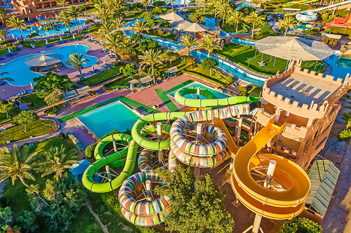 Luftaufnahme des Wasserparks im Resort, umgeben von grünen Liegewiesen und Hotelgebäuden.