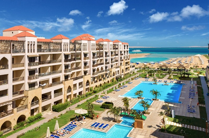 Ein Resort mit einem Pool und einem Strandbereich, ideal zum Entspannen und Genießen der Sonne.
