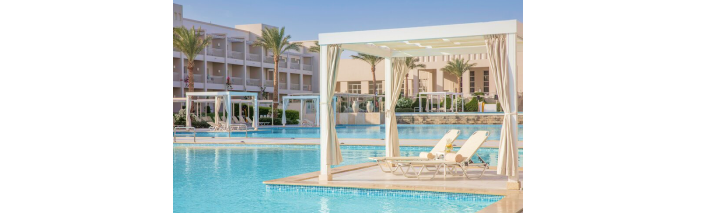 Ein elegantes weißes Gazebo neben einem Schwimmbad in einem Hotel, ideal für Entspannung.