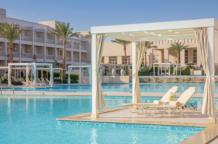 Ein elegantes weißes Gazebo neben einem Schwimmbad in einem Hotel, ideal für Entspannung.