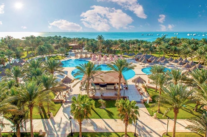Ein tropisches Resort mit Palmen und einem einladenden Pool, ideal für entspannende Urlaubstage.