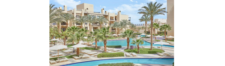 Der Resort-Pool in Hurghada, umgeben von hohen Palmen, lädt zu einem erfrischenden Bad in tropischer Umgebung ein