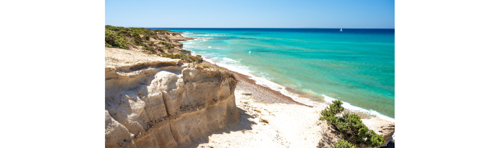 Die atemberaubenden Klippen und der feine Sandstrand der Insel Kos, umgeben von strahlend blauem Wasser.