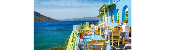 Restaurant mit Blick auf das Meer in Kreta, mit einladenden Tischen und Stühlen im Außenbereich