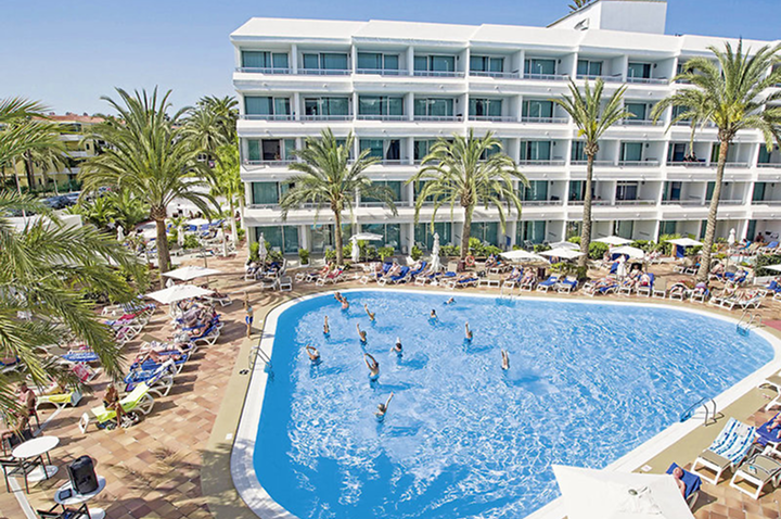 Großer Pool umgeben von Palmen und einem Hotel, ideal für entspannende Urlaubstage unter der Sonne.