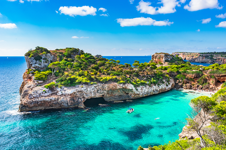 Die atemberaubend blaue Küstenlandschaft von Mallorca, Spanien, mit klarem Wasser und sonnigem Himmel.