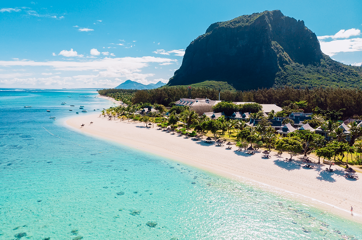 Blick von oben auf einen Strand und einen Berg in Mauritius, der die malerische Verbindung von Wasser und Natur darstellt.