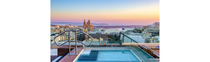 Blick von der Dachterrasse des Malta Hotels auf die Stadt mit beeindruckender Skyline und strahlendem Himmel.
