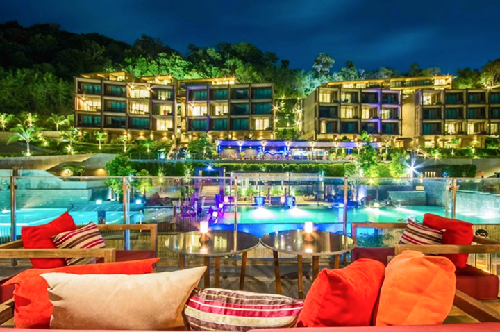 Der Resort-Pool strahlt nachts, umgeben von bequemen Liegen, einladend für erholsame Abende unter dem Nachthimmel.
