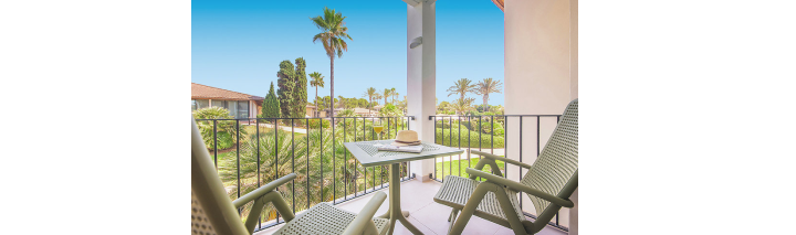 Gemütlicher Balkon mit Tisch und Stühlen, der eine schöne Aussicht auf die Landschaft zeigt.
