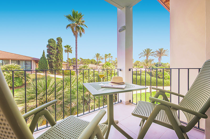 Gemütlicher Balkon mit Tisch und Stühlen, bietet eine schöne Aussicht auf das Hotel für entspannte Stunden.