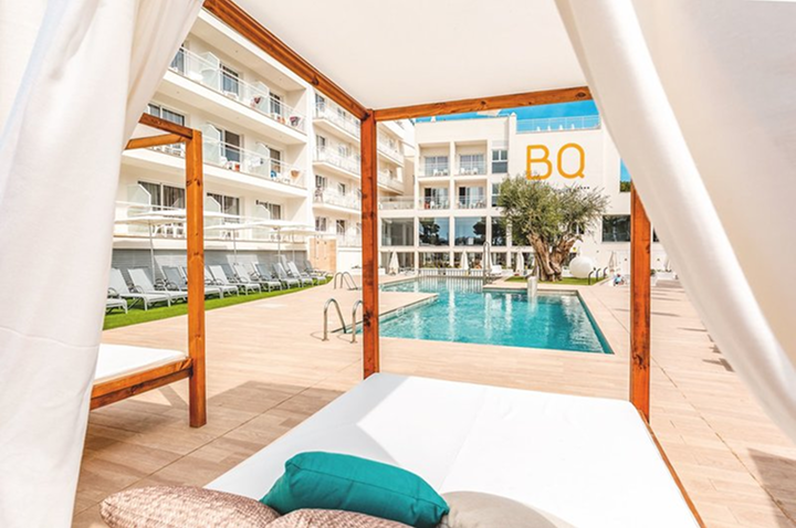 Elegante weiße Überdachung über einem Pool und Liegen im Hotelbereich.